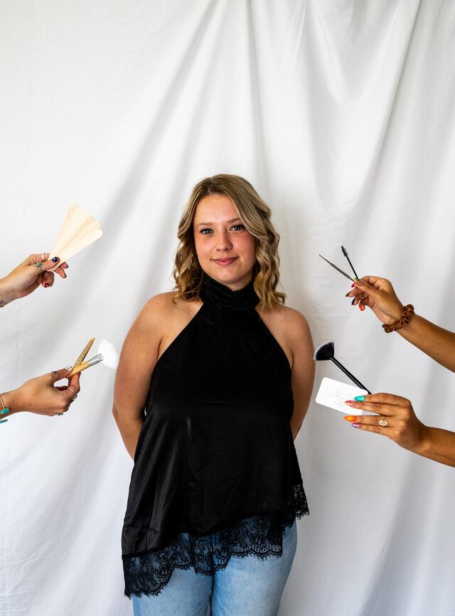Brynn surrounded by brushes and brow tools held out by the other Plush artists